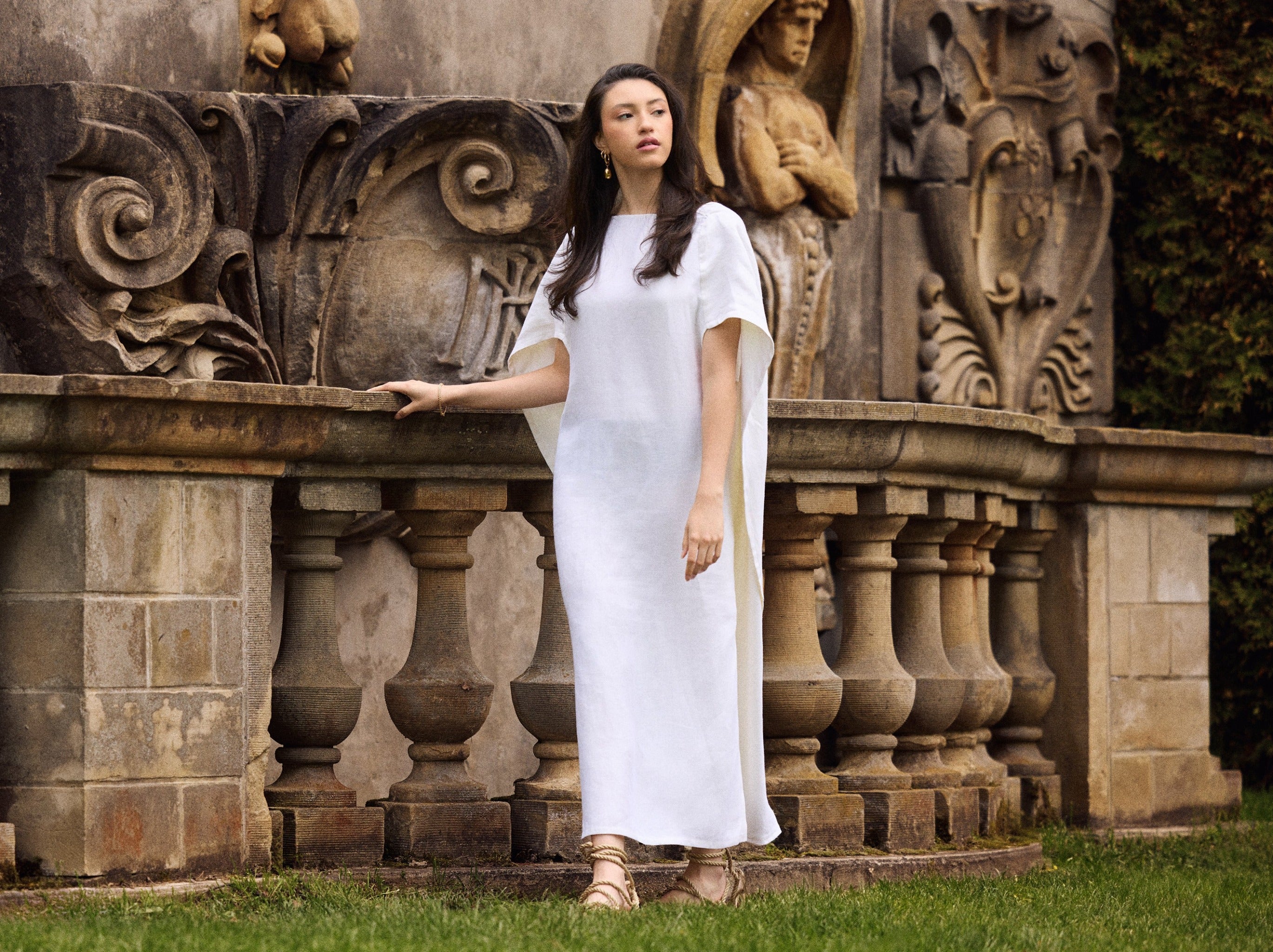Model wearing a Diana linen cape caftan in white.